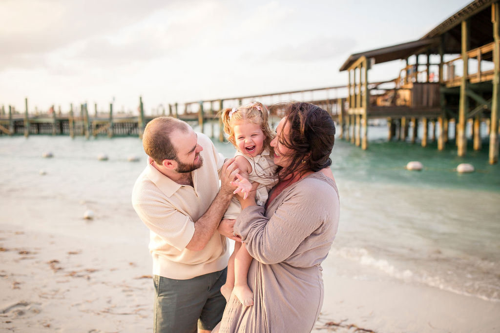 Family of 3 laughing on the beach