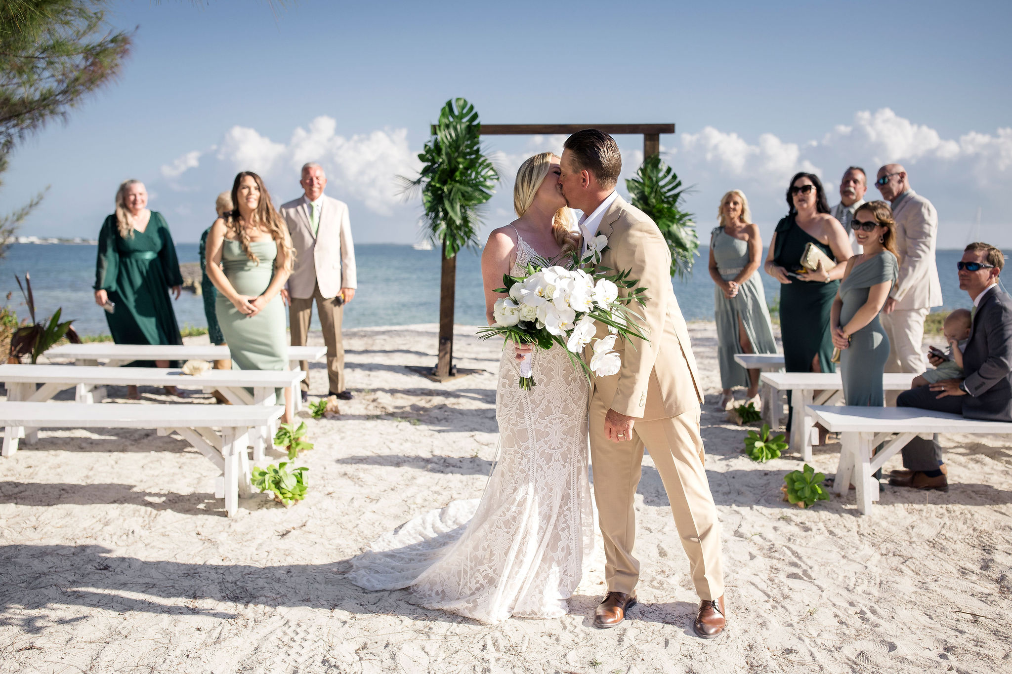 a couple kissing as they walk down the aisle