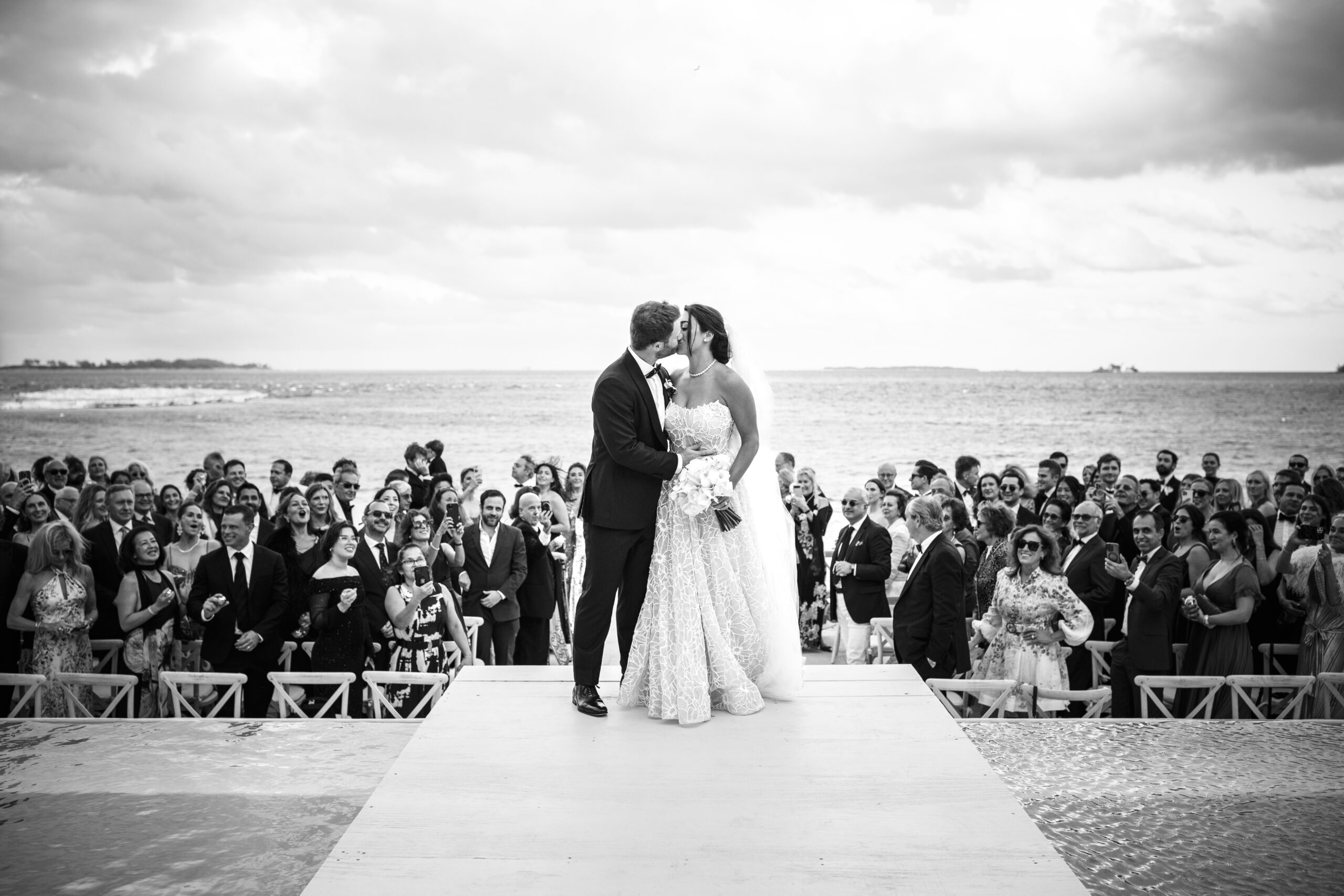 bride and groom kissing after they walk down the aisle